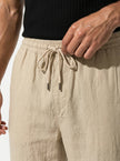 Close-up of FJØRNA men's linen trousers showing relaxed fit, breathable fabric, and lightweight summer design.