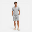 Men's textured zip polo shirt and shorts set in neutral tones, casual summer co-ord by FJØRNA, displayed on a hanger.