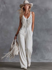 White faux suede Western fringe V-neck jumpsuit by FJØRNA, featuring fringe details and a V-neck design with long sleeves.