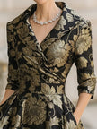 FJØRNA black and gold jacquard floral midi dress with elegant pattern and fitted silhouette, perfect for formal occasions.