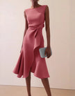 Pink FJØRNA midi dress for women with round neck, sleeveless design, ruffle details, and bow accents.