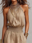 FJØRNA tan cotton linen sleeveless jumpsuit with halter neck, smocked waist, and wide-leg design, perfect for warm weather.