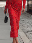 FJØRNA elegant red satin midi dress with polka dots, featuring a fitted waist and flowing skirt, perfect for formal occasions.