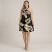 Black FJØRNA halter neck printed mini dress with flowy A-line fit, featuring floral pattern and sleeveless design.