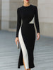 FJØRNA modern black and white asymmetric color-block midi dress with stylish design and elegant fit, displayed on a model.