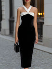 Black velvet midi dress by FJØRNA featuring a white halter neck bow detail and elegant fit for formal occasions.