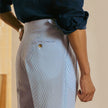 FJØRNA men's high waist straight leg tailored trousers hanging on a wooden hanger, showcasing their classic fit and clean design.