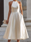FJØRNA halter-neck pleated midi dress for women, showcasing a flowy, elegant design with a fitted waist and pleated skirt.