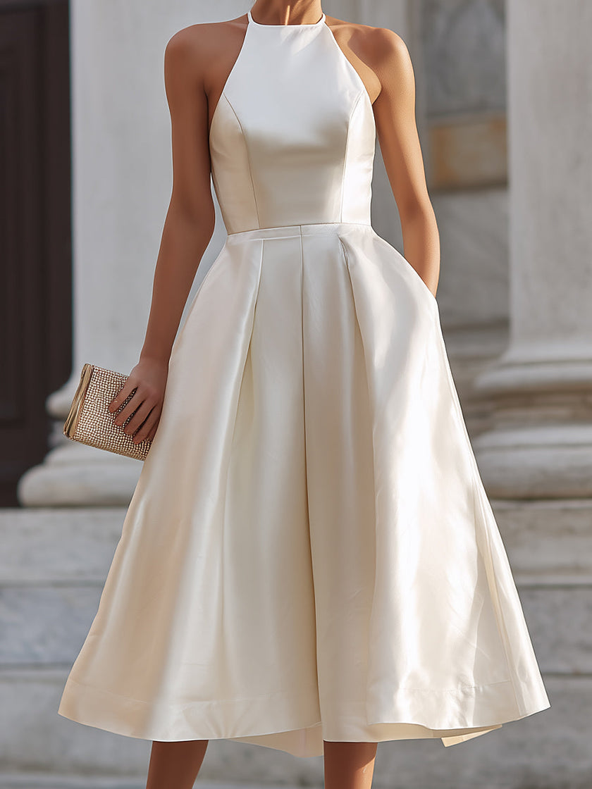 FJØRNA halter-neck pleated midi dress for women, showcasing a flowy, elegant design with a fitted waist and pleated skirt.