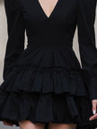 FJØRNA black leather mini dress with puff sleeves and tiered design, showcasing a stylish and dramatic mini dress silhouette.