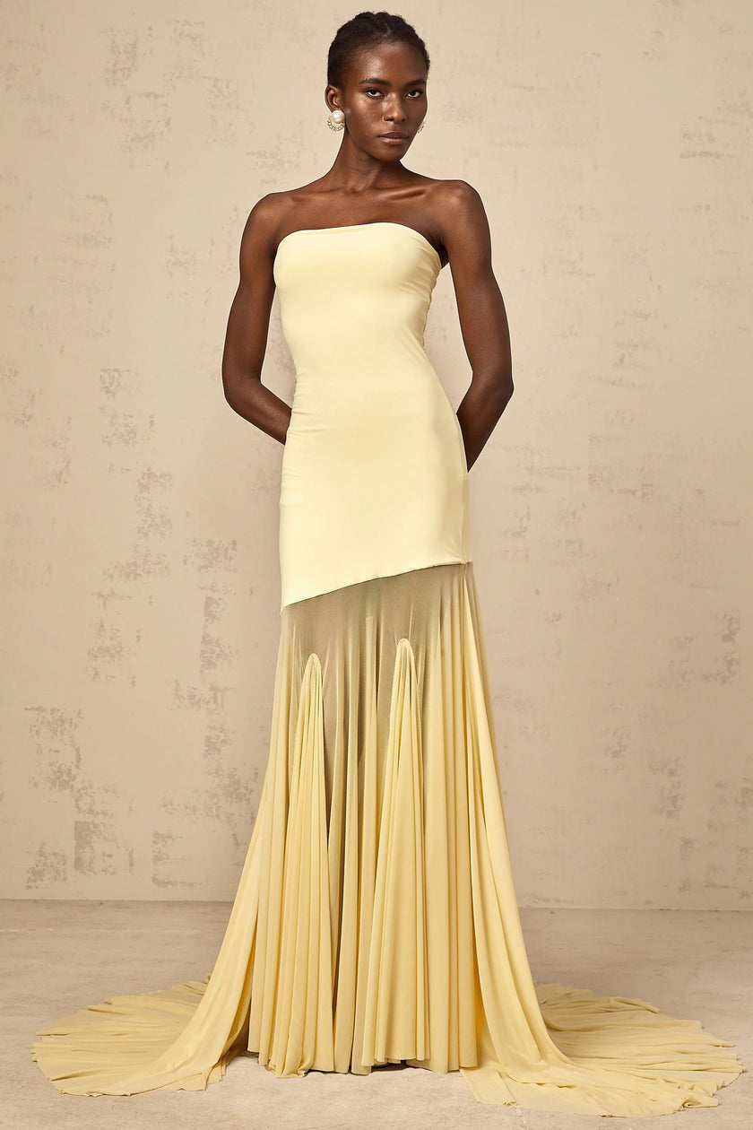 FJØRNA Josiane yellow off-shoulder sheer tulle maxi dress displayed on a model, featuring flowing fabric and elegant off-shoulder design.