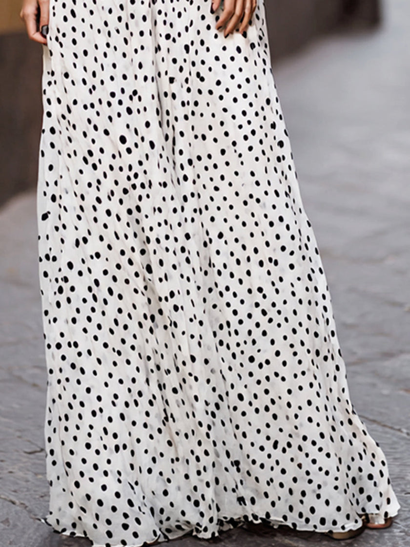 Elegant FJØRNA polka dot halter maxi dress with black lace waist inlay, flowing fabric and stylish design perfect for special occasions.