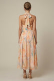 FJØRNA women's floral halter neck maxi dress with tie back, back view showing flowing fabric and floral pattern for wedding guest attire.