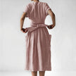 Back view of FJØRNA women's elegant midi dress with V-neck and short sleeves, showcasing a stylish, fitted silhouette.