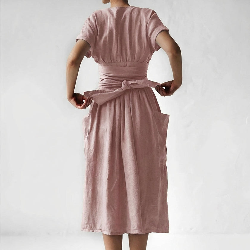 Back view of FJØRNA women's elegant midi dress with V-neck and short sleeves, showcasing a stylish, fitted silhouette.