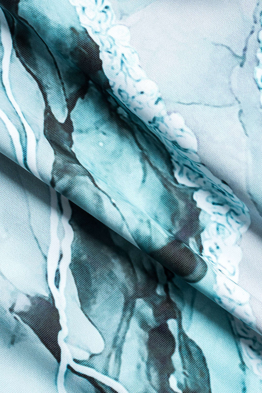 Women's abstract print swimsuit set with matching pareo by FJØRNA, featuring strappy details and stylish design.