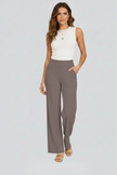 FJØRNA Bianca women's high-rise wide-leg trousers hanging on a rack, showcasing their flowy fabric and tailored fit.