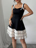 Black FJØRNA summer party dress with a mini length and side bow, stylish dress perfect for festive occasions.
