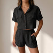 FJØRNA black relaxed collared two-piece shorts set in lightweight textured woven fabric, casual and comfortable for warm weather.
