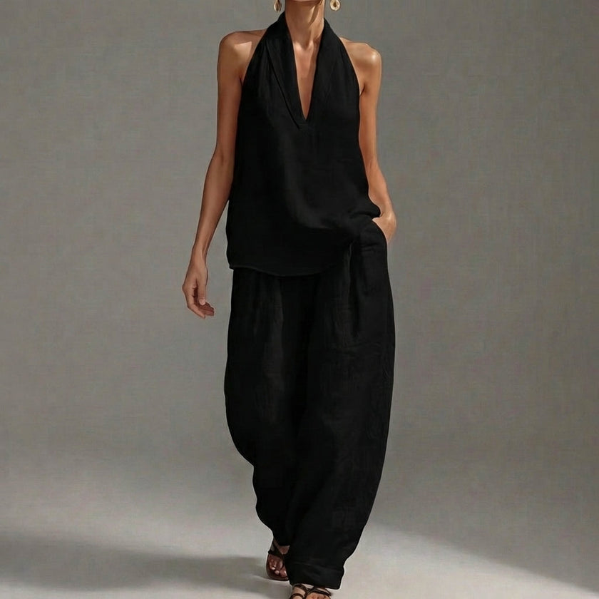 Black FJØRNA two-piece halter V-neck suit with wide-leg trousers, stylish and lightweight for casual or semi-formal wear.