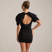 Black puff sleeve bodycon mini dress with high neck by FJØRNA, shown from the back with a fitted silhouette and stylish design.
