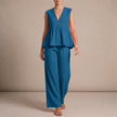 Blue women's summer two-piece co-ord set with wide-leg pants and V-neck top from FJØRNA, displayed on a hanger.
