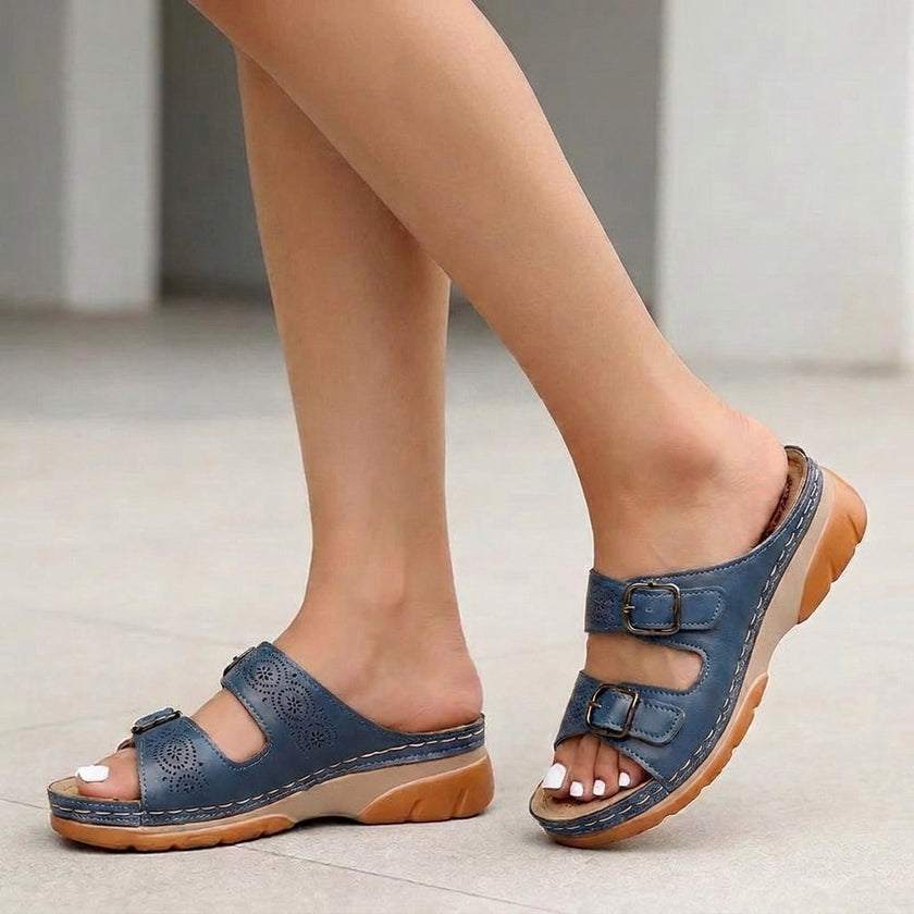 Blue FJØRNA orthopedic buckle platform slide sandals for women shown on a foot, featuring a secure buckle strap and chunky sole.