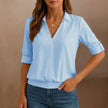 Blue V-neck denim blouse for women by FJØRNA, stylish summer top with a relaxed fit and classic denim texture.