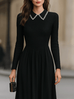 FJØRNA black long-sleeve midi dress with embellished collar, featuring a fitted silhouette and elegant design.