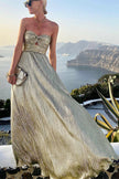 FJØRNA Celeste women's strapless A-line evening gown with pleated metallic fabric and elegant design.