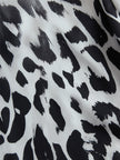 White leopard print chiffon wide-leg trousers for women by FJØRNA, featuring flowy fabric and relaxed fit.