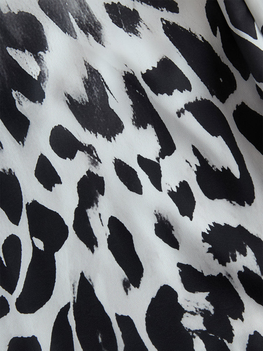 White leopard print chiffon wide-leg trousers for women by FJØRNA, featuring flowy fabric and relaxed fit.