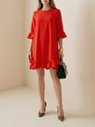 FJØRNA falbala solid color round-neck midi dress displayed on a hanger, showcasing its elegant design and smooth fabric.