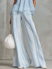 Light blue striped chiffon wide-leg trousers by FJØRNA, showing the flowy fabric and relaxed fit of these stylish pants.