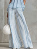 Light blue striped chiffon wide-leg trousers by FJØRNA, showing the flowy fabric and relaxed fit of these stylish pants.