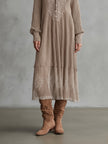 FJØRNA Whispered Snow Knit Maxi Dress displayed on a hanger, showcasing its soft knit fabric and flowing silhouette.
