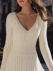 FJØRNA cozy cable knit sweater dress with V-neck, flare hem, mini length, worn by a woman showing the front view.
