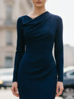 Navy FJØRNA draped midi dress with flowing fabric and elegant silhouette, displayed on a hanger against a neutral background.
