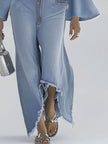 Light blue denim flared long sleeve jumpsuit by FJØRNA with wide-leg design and button-up front, styled for casual wear.