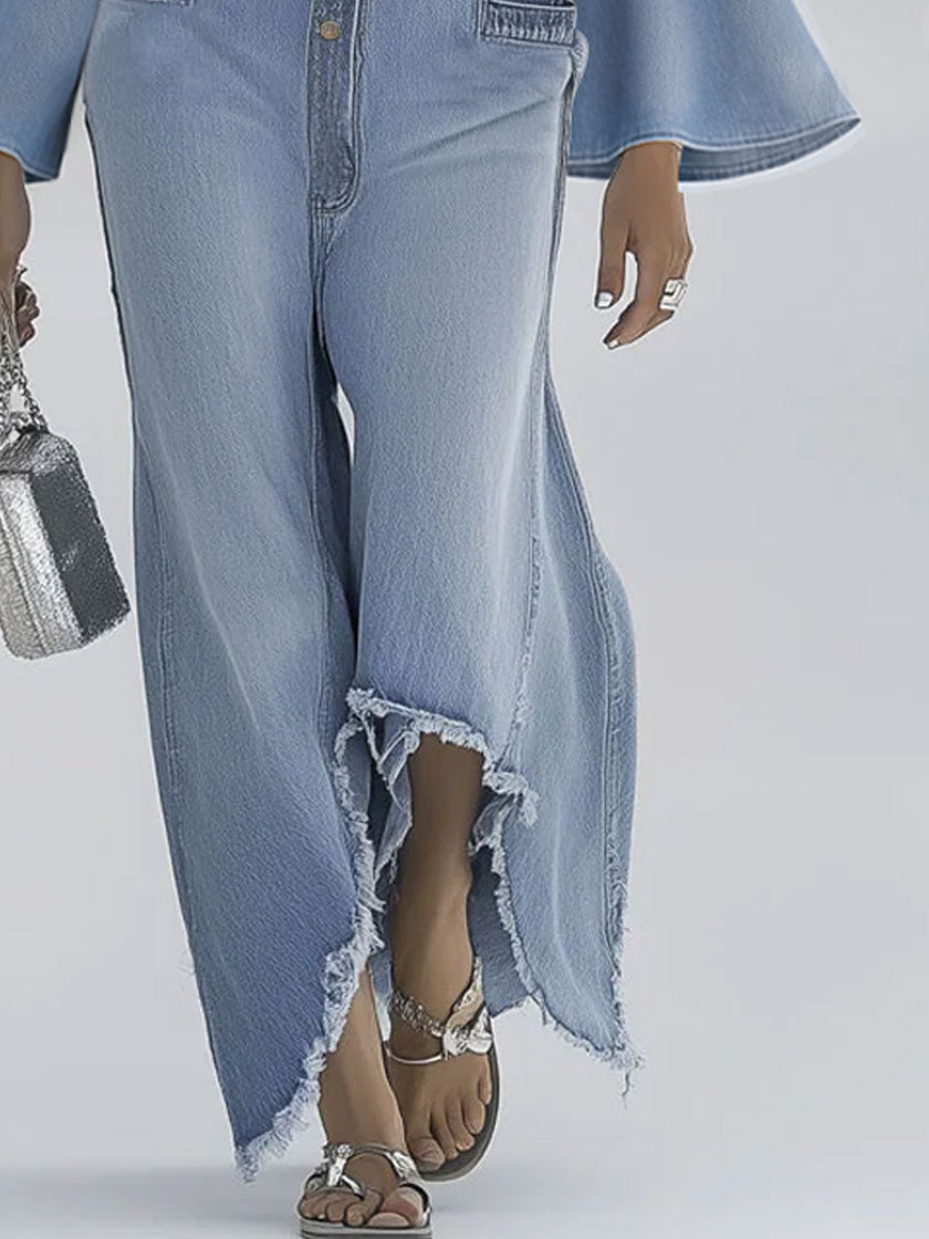 Light blue denim flared long sleeve jumpsuit by FJØRNA with wide-leg design and button-up front, styled for casual wear.