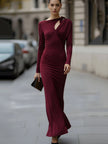 FJØRNA elegant long-sleeve draped cutout evening gown, a stylish black maxi dress with flowing fabric and sophisticated design.