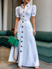 White FJØRNA maxi dress with puff short sleeves, belted waist, button details, and a lapel collar, perfect for elegant summer wear.