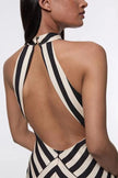 FJØRNA Mono Fluid Stripe Maxi Halter Dress displayed on a mannequin, featuring a flowing maxi dress with bold stripe patterns.