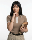 FJØRNA women's cotton polo top, light blue, short sleeves, classic collar, casual style, close-up of front and collar details.