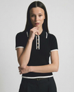FJØRNA women's cotton polo top, classic short-sleeve shirt with collar and button placket, in soft white fabric.