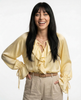 FJØRNA satin women's blouse with ruffle detail, stylish top featuring elegant fabric and feminine design.