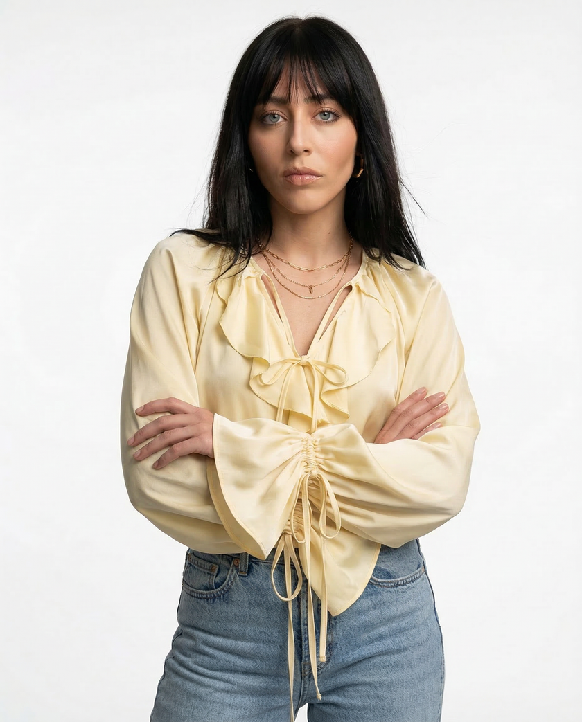 FJØRNA satin women's blouse with ruffle details, elegant top featuring smooth fabric and feminine design.