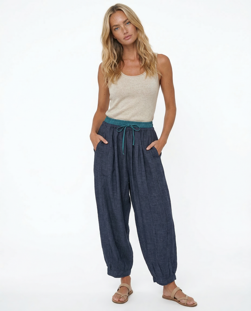 Light beige linen tapered trousers for women by FJØRNA, featuring a relaxed fit and casual style.