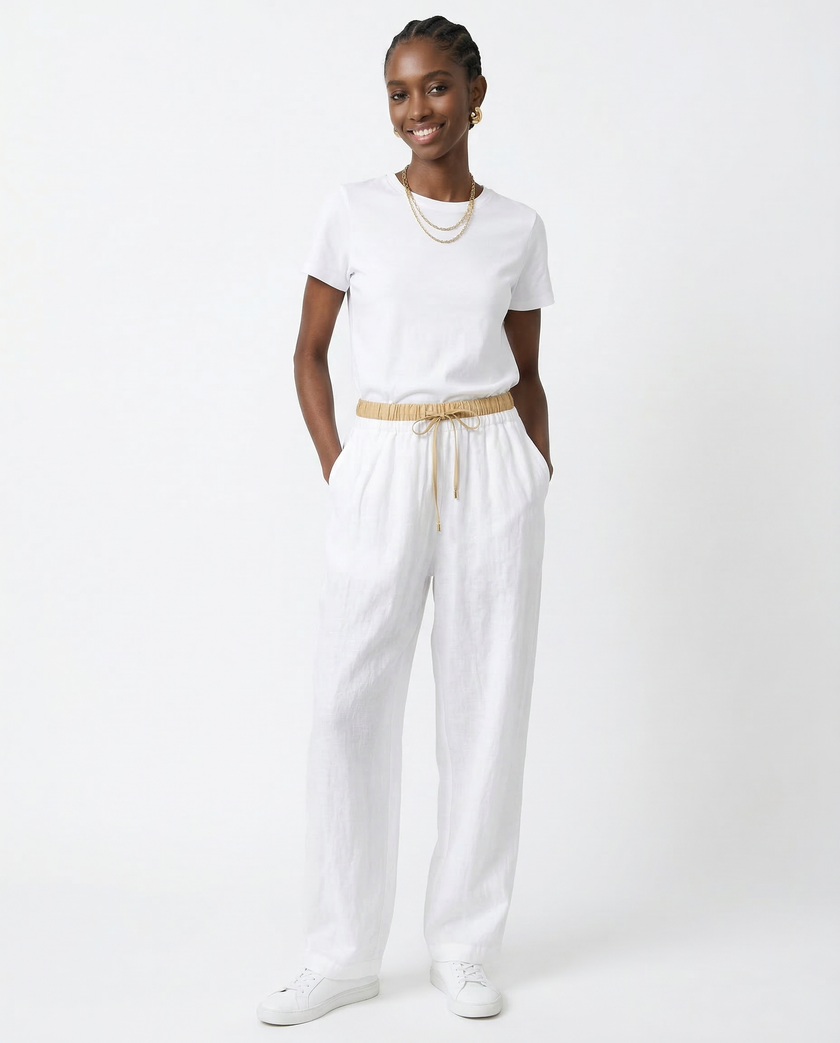 FJØRNA women's linen tapered trousers, light and breathable pants with a relaxed fit, shown in a natural beige color.