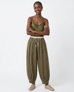 FJØRNA women's linen tapered trousers, lightweight and breathable pants with a relaxed fit, shown in a natural beige color.